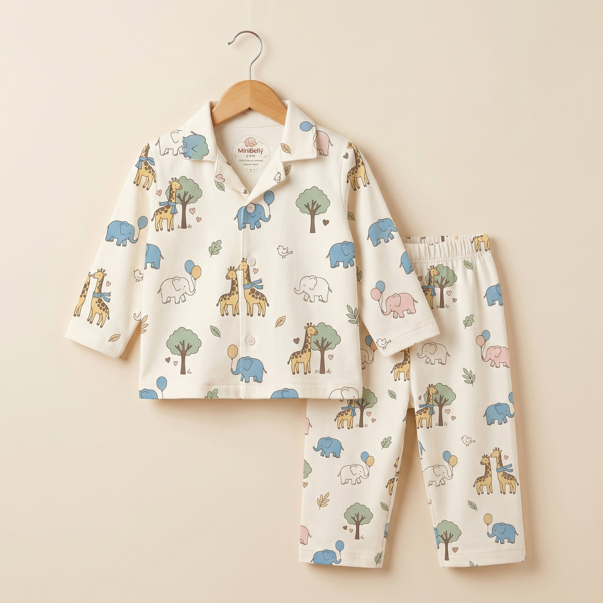 MiniBelly kids' night suit featuring cute cartoon elephants, giraffes, balloons, and trees on 100% cotton cream fabric for ages 0-6 months.